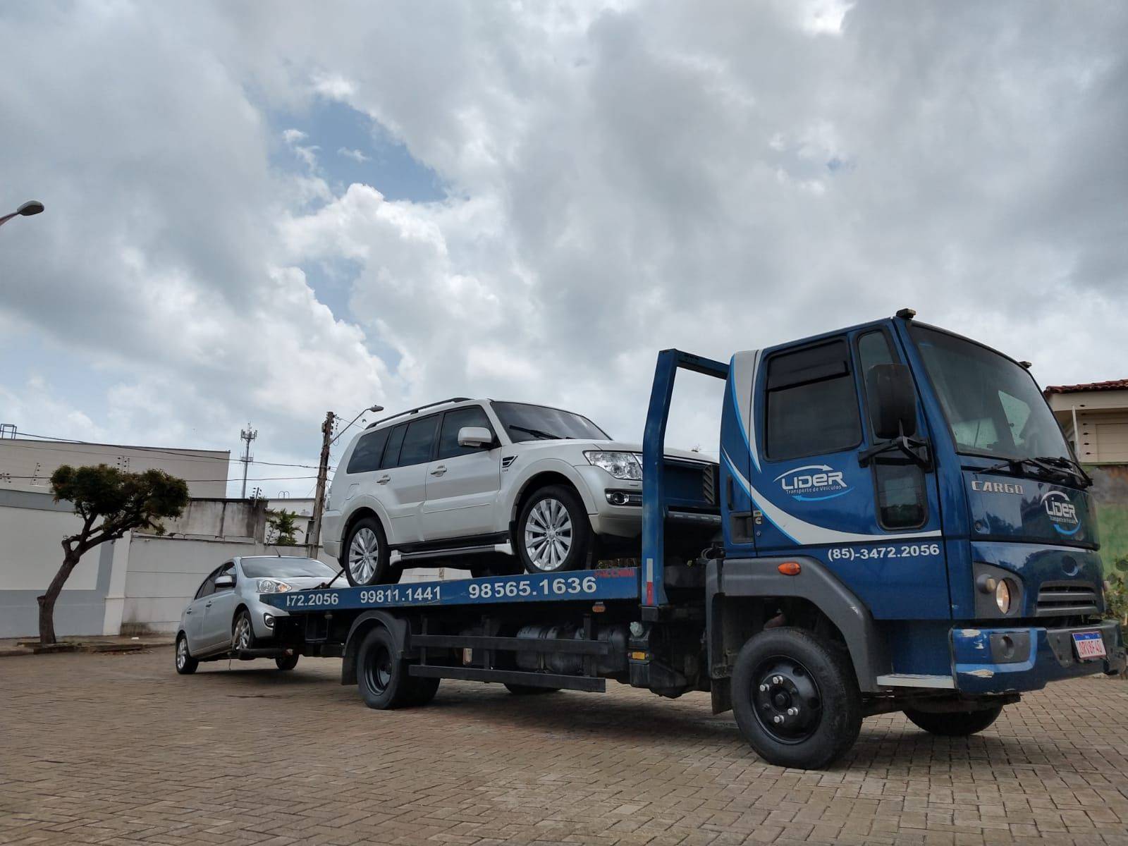 caminhão da lider transporte com um carro na plataforma e um no guincho