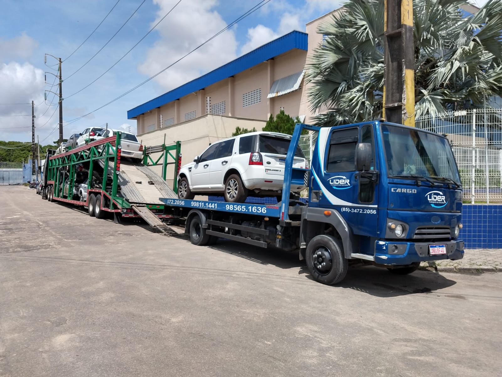 caminhão prancha estacionado com carro popular em cima