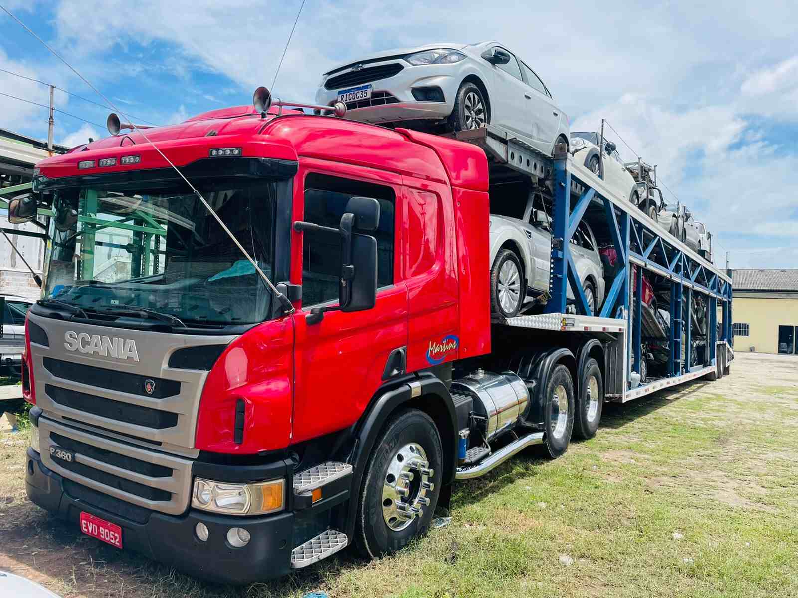 caminhão cegonha vermelho carregado com carros